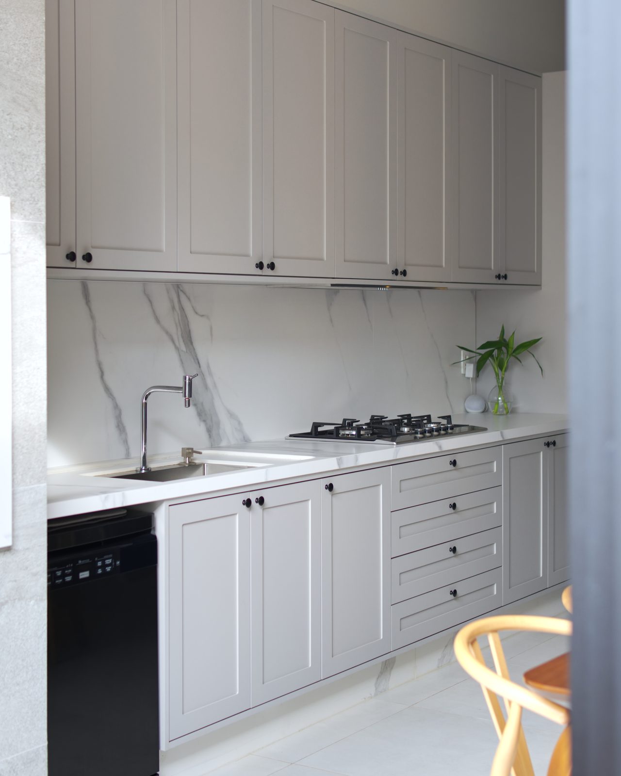 Bancada de cozinha em porcelanato marmorizado, com cooktop de cinco bocas e cuba dupla embutida